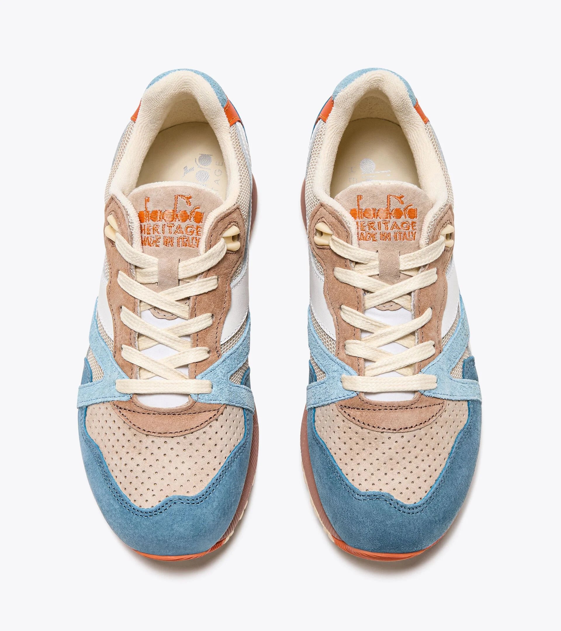 A pair of Ace Rivington Diadora - N9000 Tourney Italia - Blue, viewed from above features a combination of blue, beige, and white suede and mesh materials, with cream-colored laces. The tongue of each shoe has the Diadora Heritage logo and 'Made in Italy' text in orange. The design includes perforated detailing on the toe box and a mix of textures and colors, giving the sneakers a stylish and vintage look.