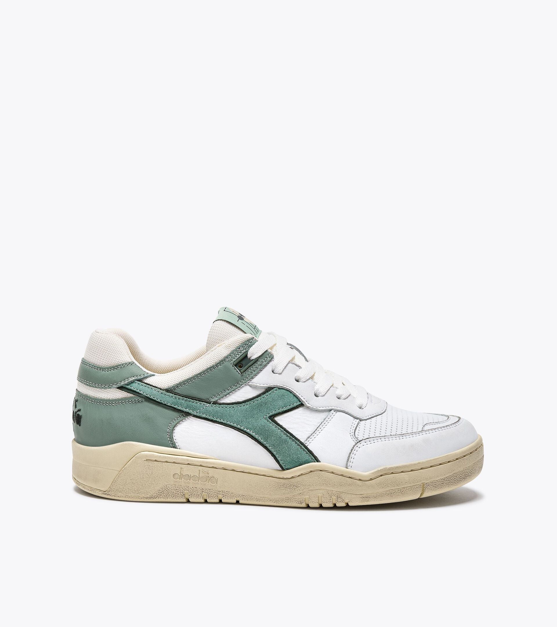 Side view of Ace Rivington Diadora B. 560 USED - Iceberg Green shoe features a white leather upper with green suede overlays, a beige midsole, and a textured rubber outsole. The Diadora logo is prominently displayed on the side in green, with additional branding on the heel and tongue.