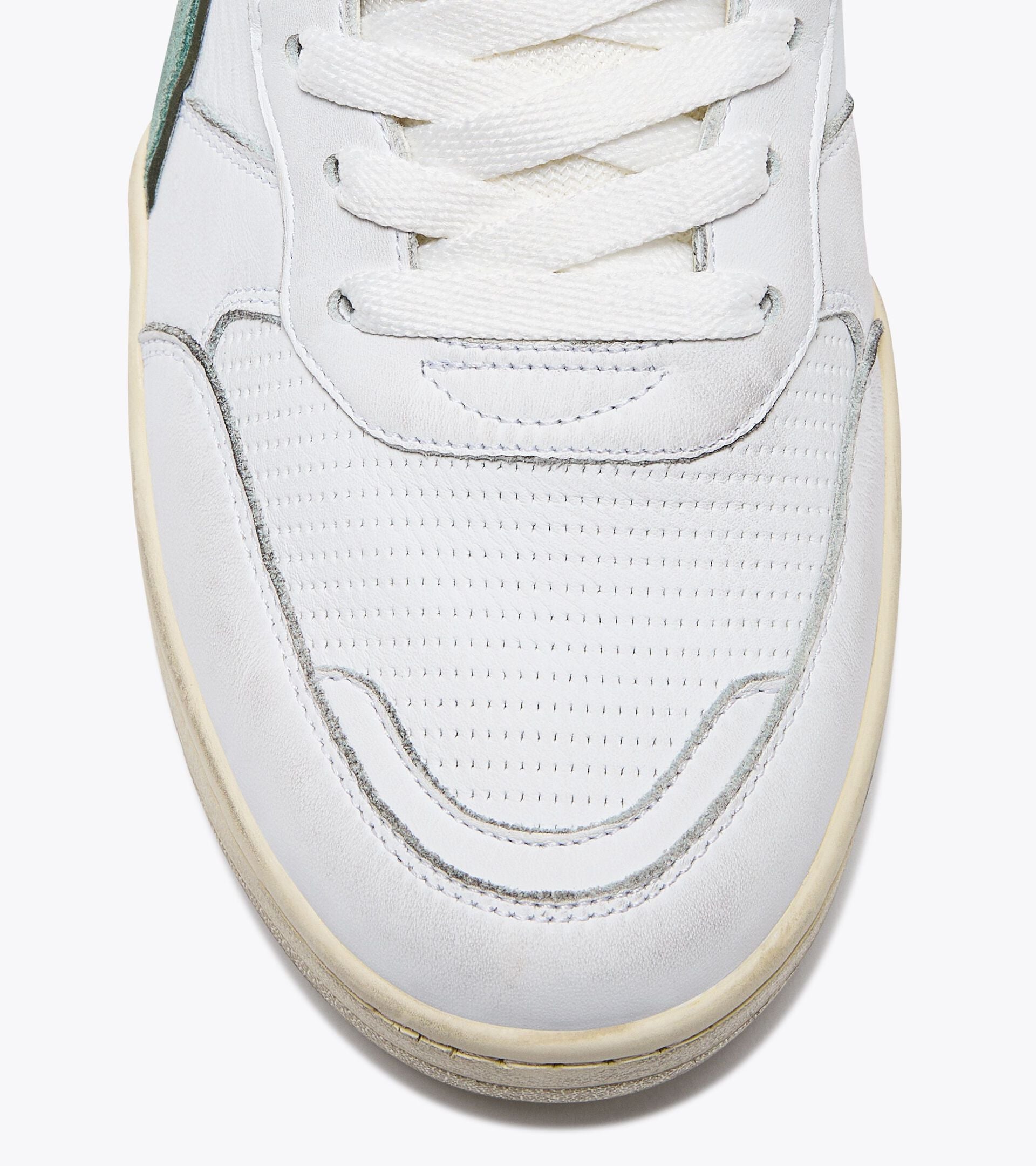 Close-up view of the toe area of an Ace Rivington Diadora B. 560 USED - Iceberg Green shoe features white leather with perforations for breathability, white laces, and a slightly worn sole. The stitching and design details are visible, highlighting the craftsmanship of the sneaker.