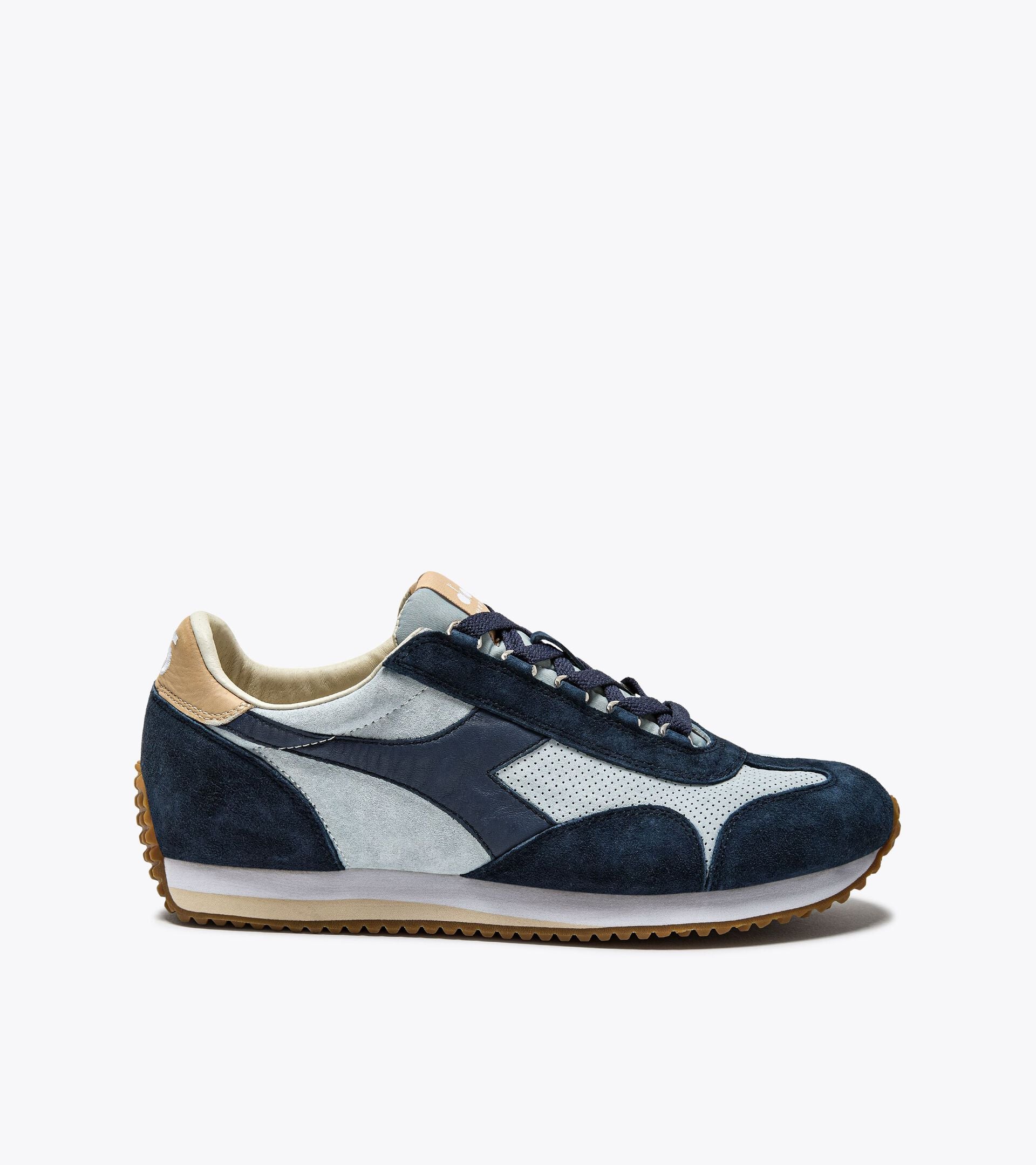 Side view of an Ace Rivington Diadora Equipe Suede SW - High Rise shoe features a combination of dark blue and light grey suede panels with a beige accent on the heel. It has a white midsole and a brown rubber outsole with a textured pattern for grip. The laces are dark blue, matching the darker suede sections of the shoe.