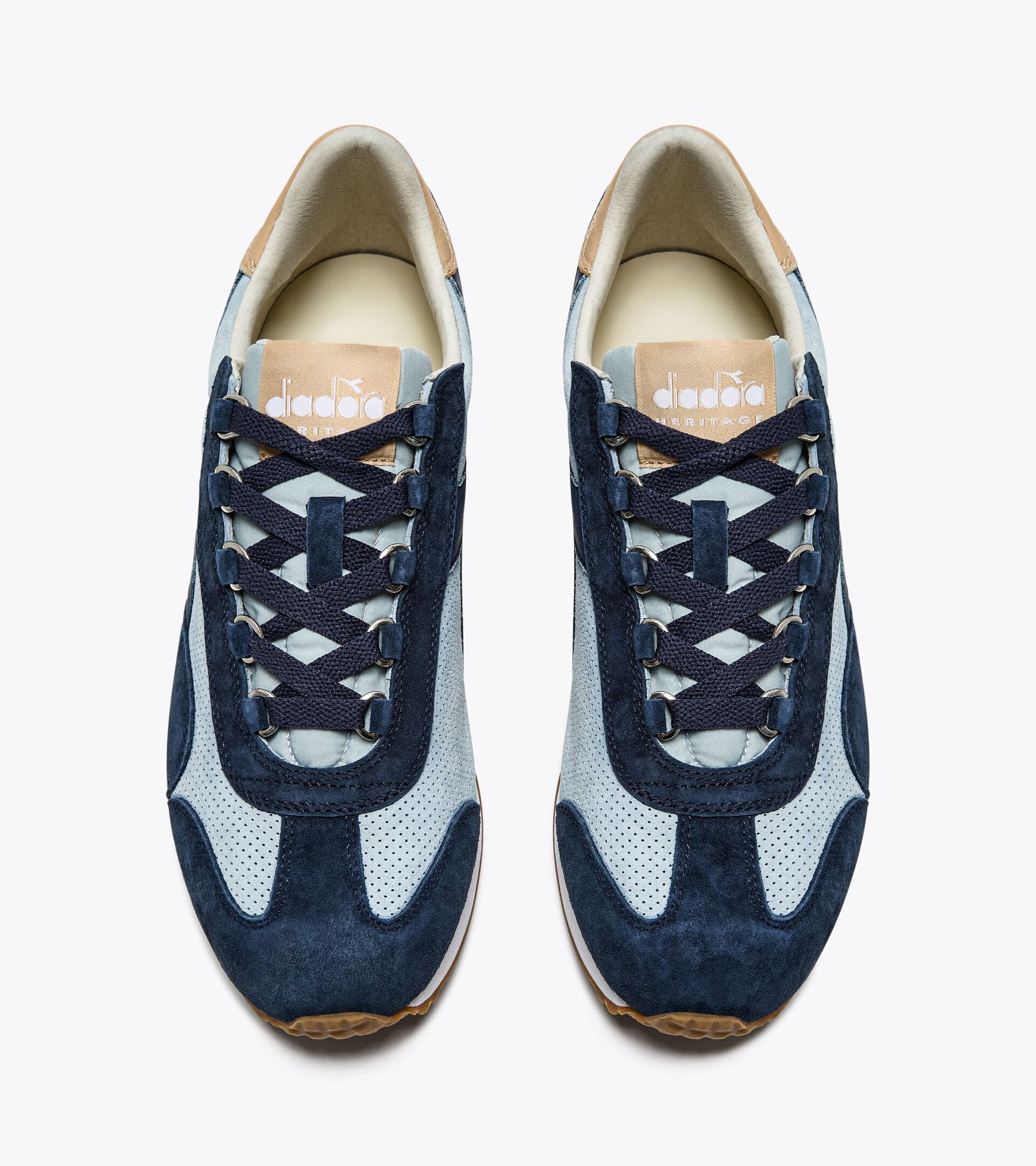 Top view of a pair of Ace Rivington Diadora Equipe Suede SW - High Rise shoes features a combination of light blue and navy suede with perforated detailing and navy laces. The Diadora logo is visible on the tongue of the left shoe.