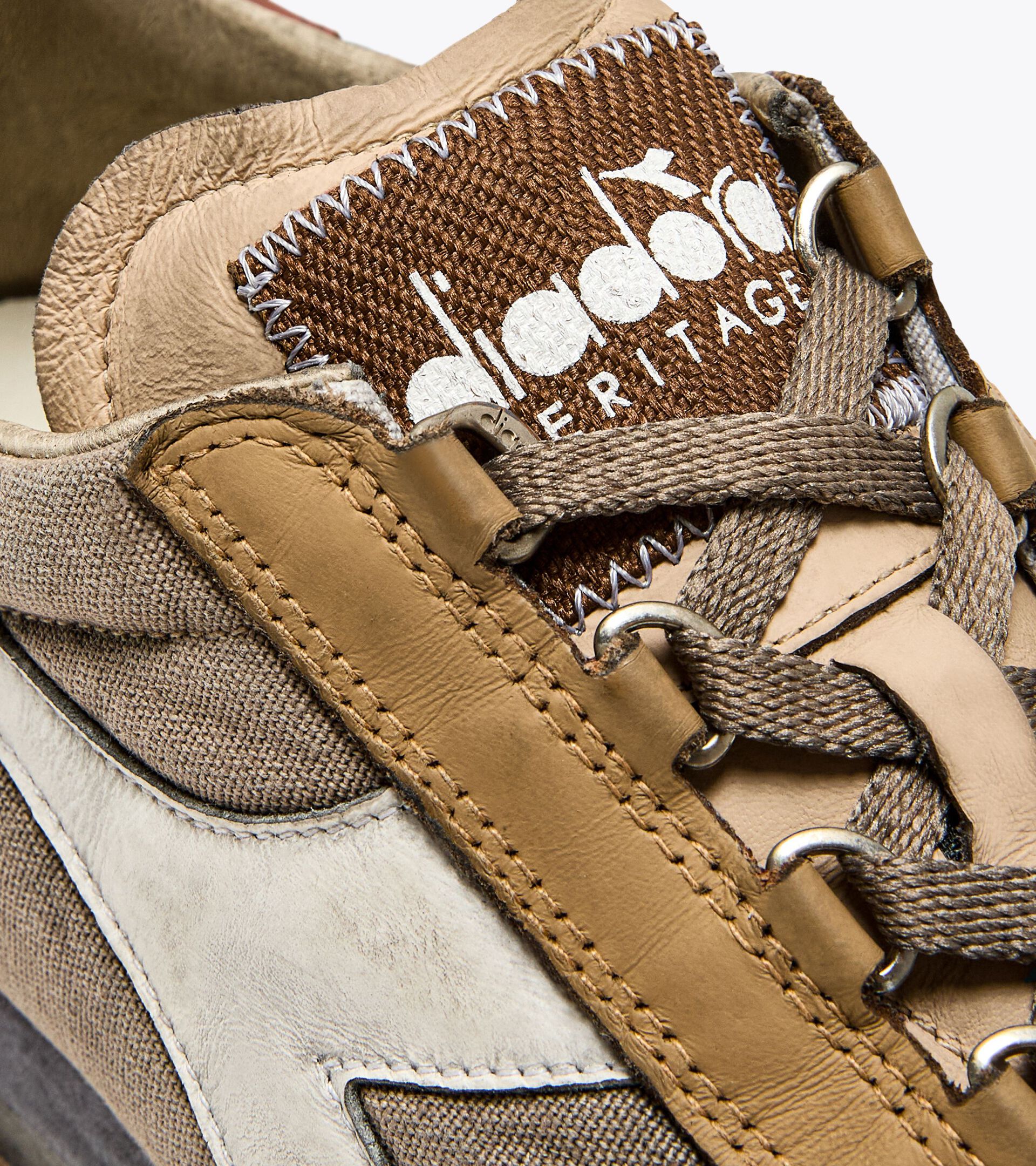 Right-pair close-up view of an Ace Rivington Diadora - Equipe Dirty SW Heritage sneaker in Cuban Sand color, featuring detailed stitching, brown and beige leather, and fabric materials. The shoe’s tongue displays the Diadora Heritage logo in white on a brown background, with beige laces threaded through metal eyelets.