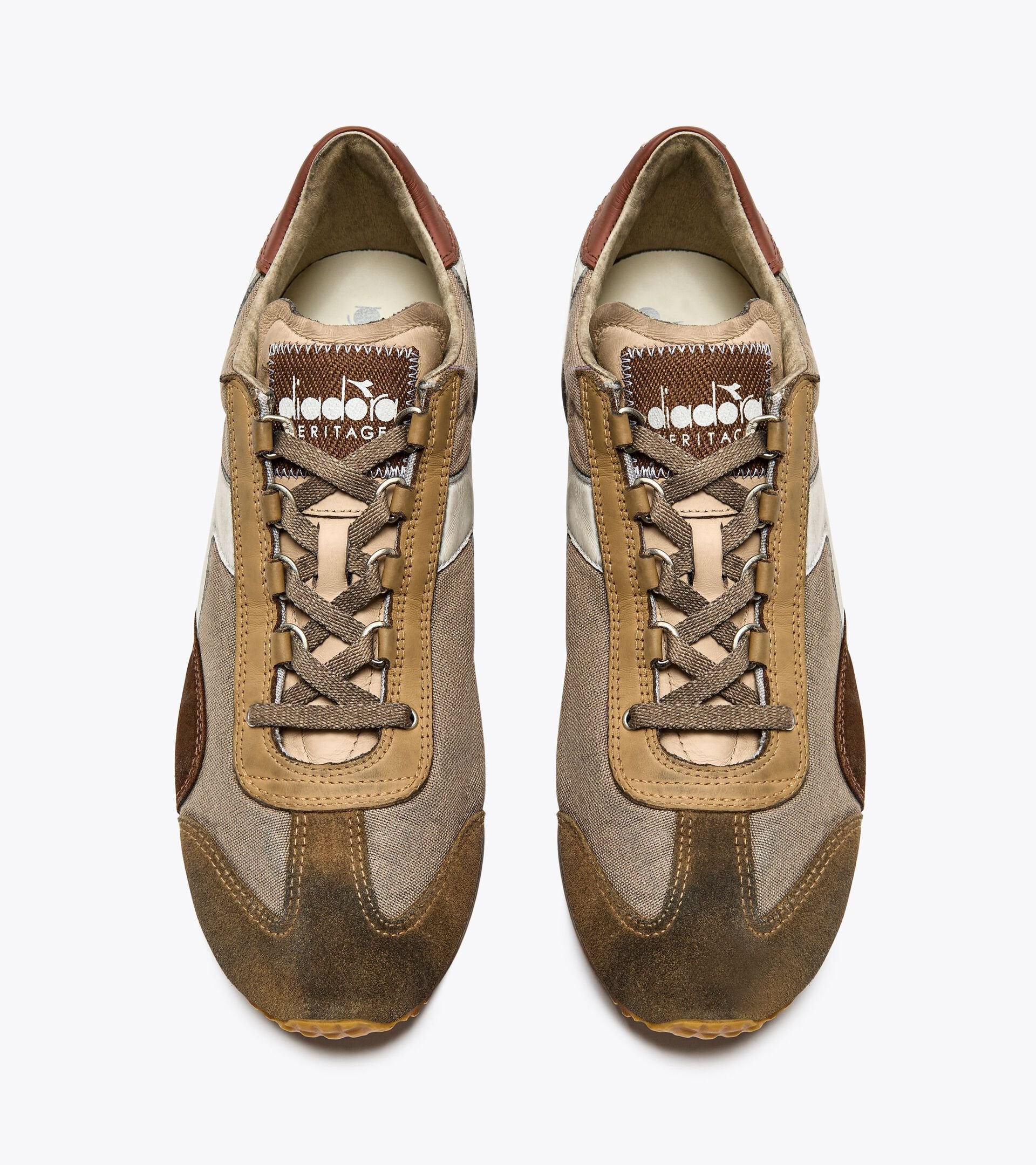 Top view of a pair of Ace Rivington Diadora Equipe Dirty SW sneakers in Cuban Sand color features a mix of brown, tan, and beige tones with suede and mesh materials. The laces are brown, and the tongue displays the Diadora logo and 'Heritage' text.