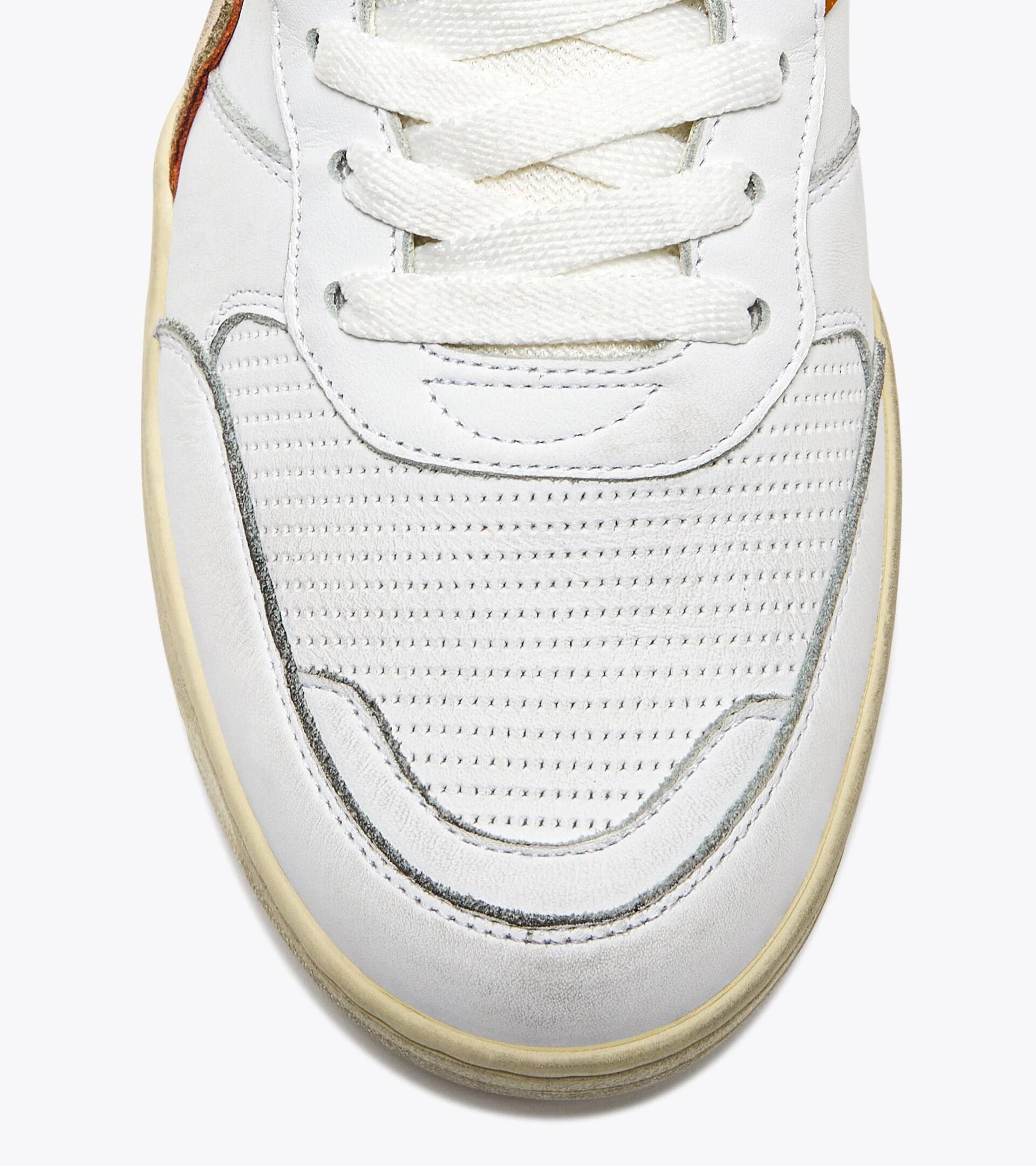 Close-up view of the toe area of an Ace Rivington Diadora B. 560 USED - Beige Bleached shoe features white laces, perforated white leather on the toe box, and beige accents along the edges. The stitching and detailing are visible, highlighting the craftsmanship of the sneaker.