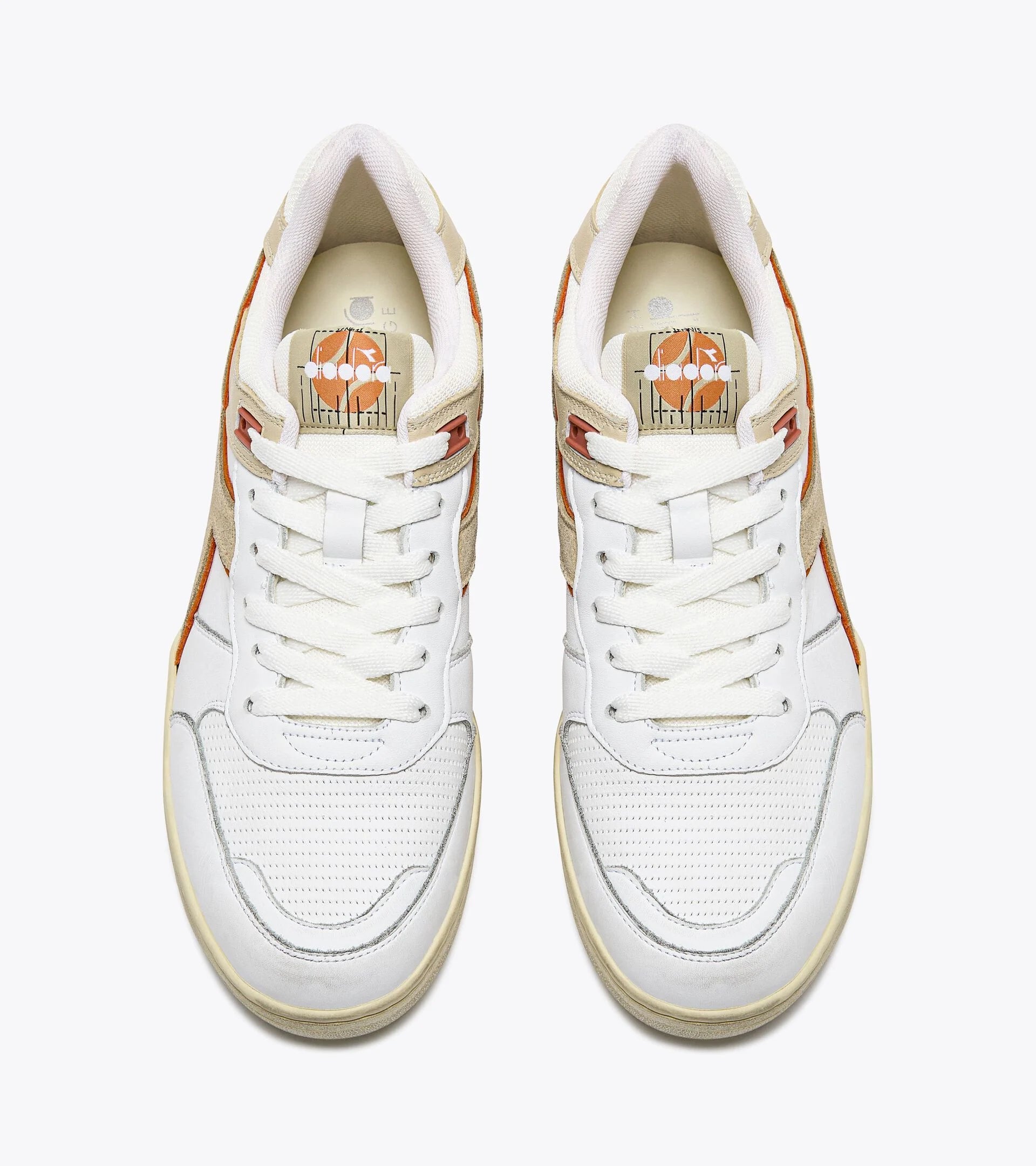 A top-down view of a pair of Ace Rivington Diadora B. 560 USED - Beige Bleached sneakers features white laces, perforated white toe boxes, and beige and orange accents on the sides. The insoles display a graphic of an orange basketball with white flowers and a net design. The sneakers have a vintage and stylish appearance.