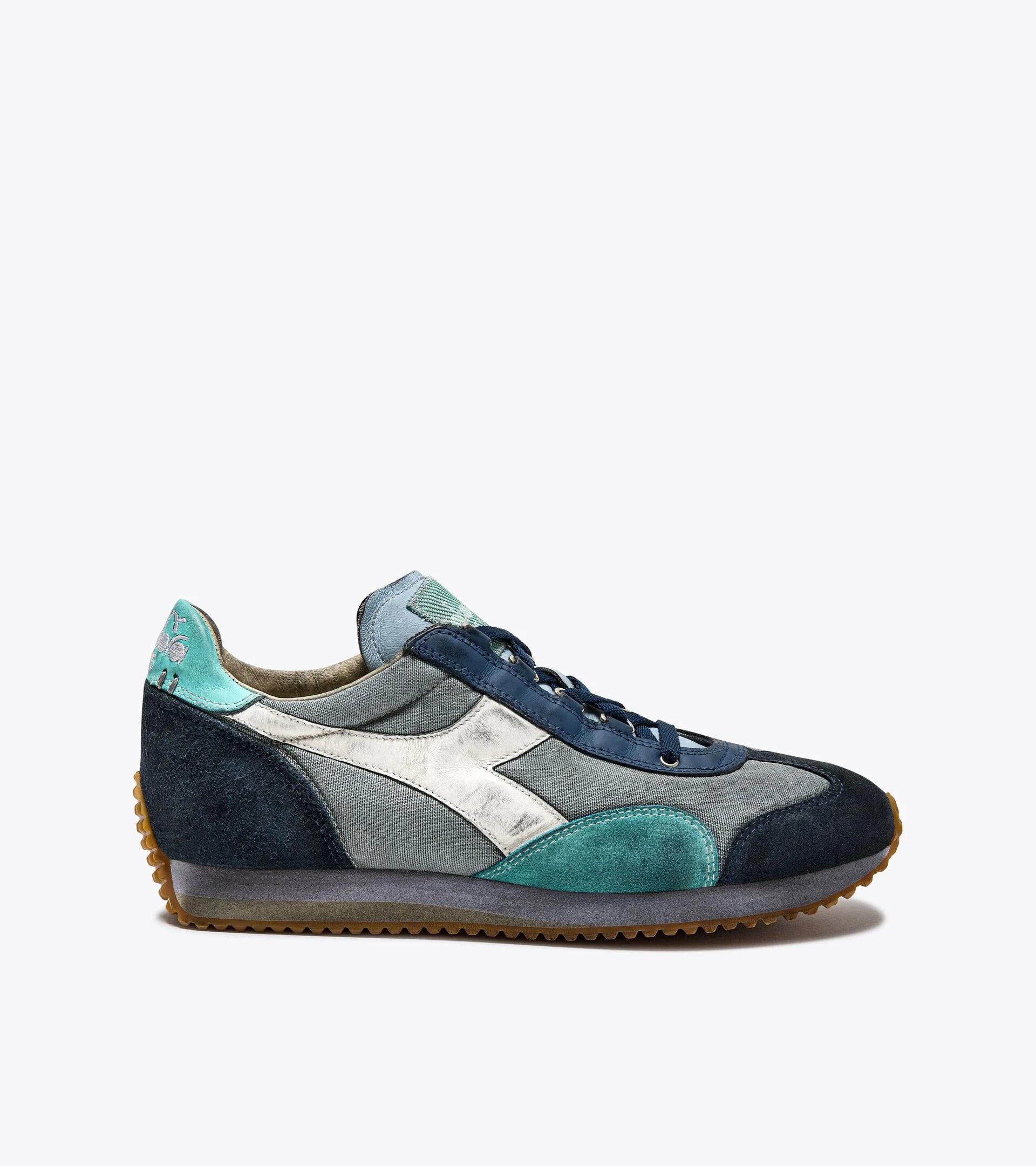 Right-pair side view of Ace Rivington Diadora - Equipe Dirty SW EVO sneaker in Light Sky Blue. The shoe features a mix of suede and fabric materials in various shades of blue, with a white logo on the side. The sole is brown with a textured grip pattern.