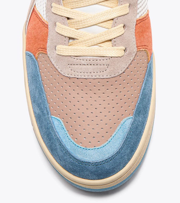 Close-up view of the toe area of an Ace Rivington Diadora B. 560 USED - Tourney Italia shoe features a combination of materials and colors, including blue, light blue, beige, tan, and orange suede overlays, with perforated tan leather on the toe box. The laces are beige, and the stitching and craftsmanship are detailed and precise.