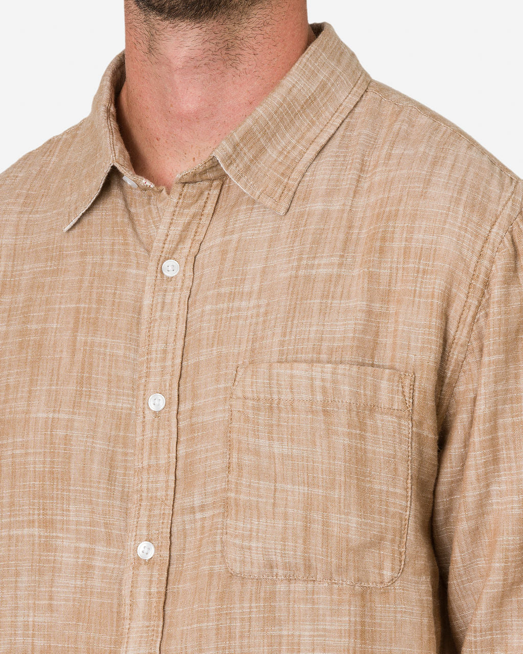 Man wearing a Double Gauze - Long Sleeve - Camel-colored shirt with a textured fabric. The shirt features a collar, a chest pocket on the left side, and white buttons.