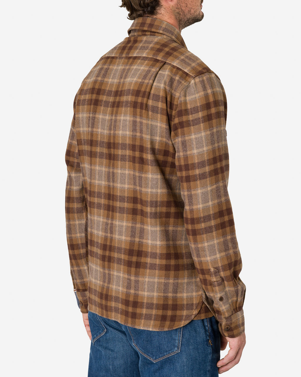 Man is shown from the back wearing a long-sleeved, flannel - Utility Shirt - Desert Bark color by Ace Rivington. The shirt has a classic checkered pattern and is paired with blue jeans. The image focuses on the upper body and the back of the shirt, highlighting the pattern and fit of the garment.