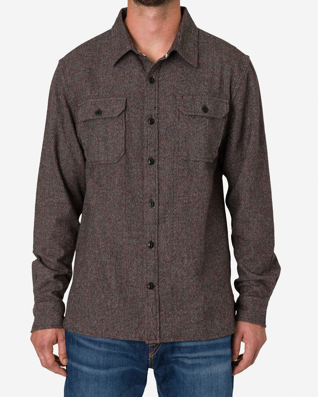 A man is wearing an Ace Rivington long-sleeved, button-up flannel utility shirt in iron opal color, featuring a subtle striped pattern in shades of brown and gray. The fabric blend offers a rich, woven appearance, making this shirt suitable for casual and semi-formal occasions. The shirt includes two chest pockets with buttoned flaps and is paired with blue jeans. The image focuses on the upper body, highlighting the design and fit of the shirt.