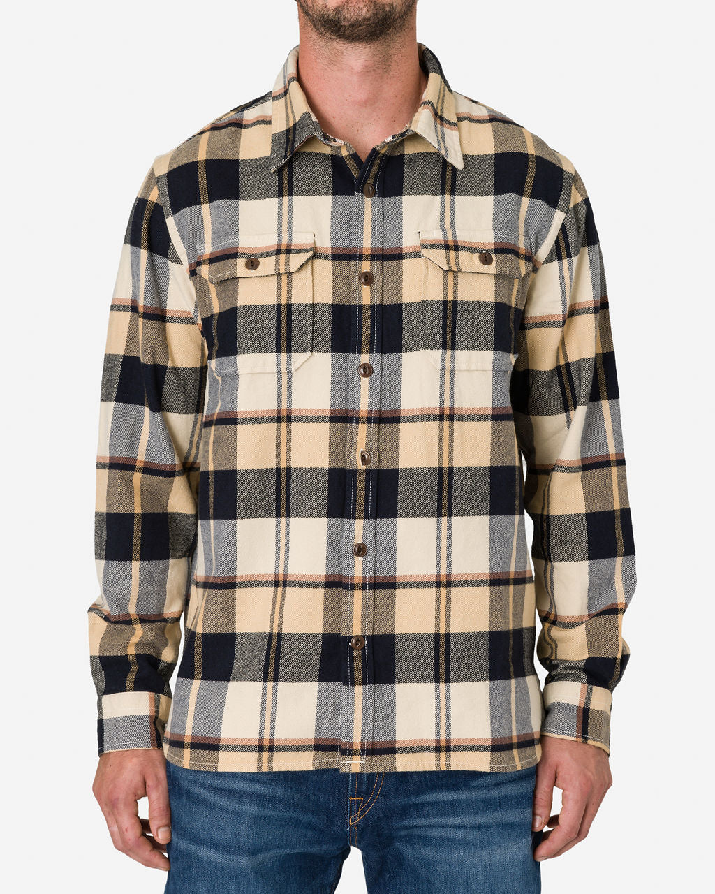 Man wearing a Midnight Dune - Flannel Utility long-sleeve, button-up shirt with a plaid pattern in shades of beige, black, gray, and yellow by Ace Rivington. The shirt has two chest pockets with buttoned flaps and is paired with blue jeans. The person is standing on a plain white background.