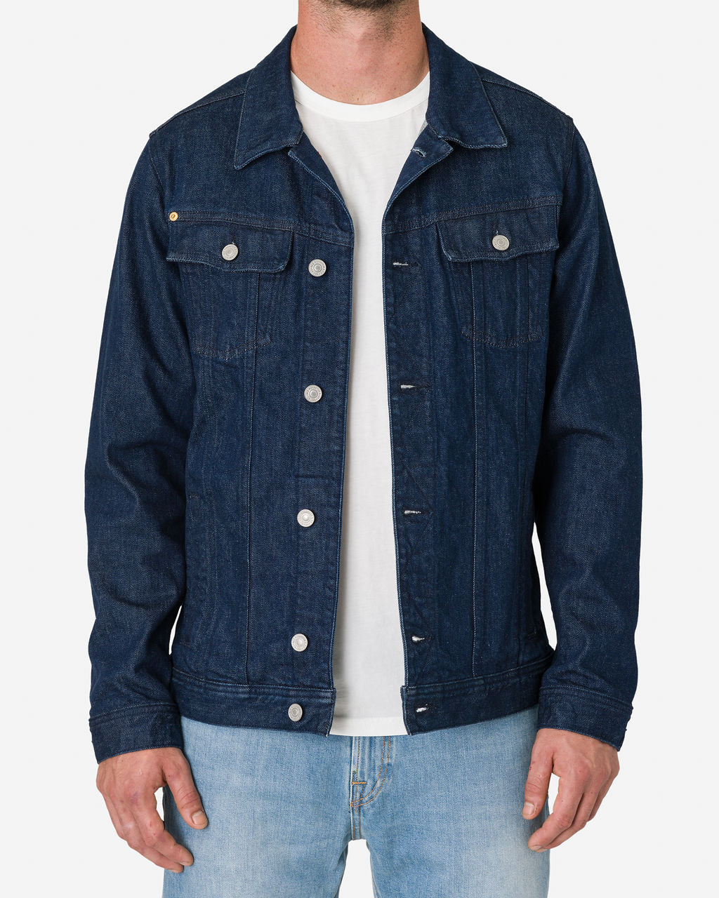 Man wearing an Ace Rivington Denim Dark Rinse Jacket over a white t-shirt and light blue jeans.