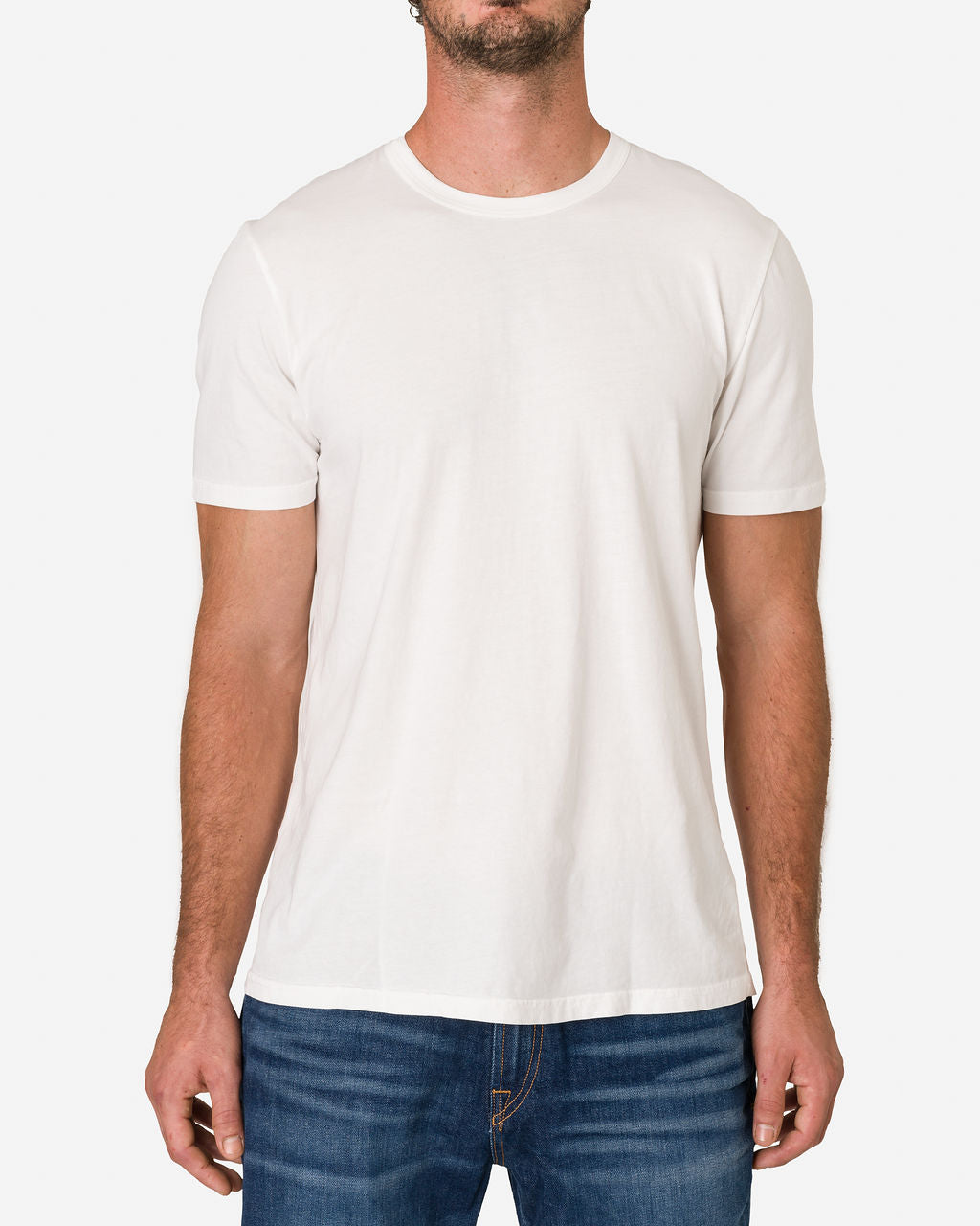 A man is wearing an Ace Rivington Super Soft Supima Cotton Tee in Chalk color, paired with blue jeans while focusing on his upper body. The shirt is plain white, featuring a crew neck and short sleeves, which highlights its fit and style.