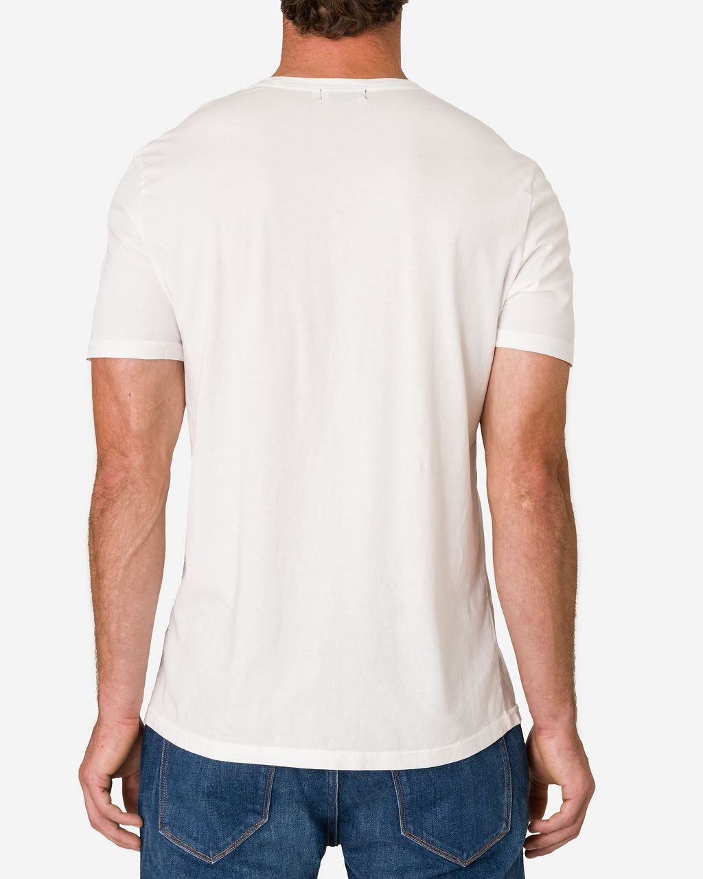 Man shown from the back wearing an Ace Rivington Super Soft Supima Cotton Tee in Chalk color paired with blue jeans. The T-shirt has a simple design with short sleeves and a slightly curved hem. The image highlights the fit and style of the t-shirt, emphasizing its casual and comfortable look.