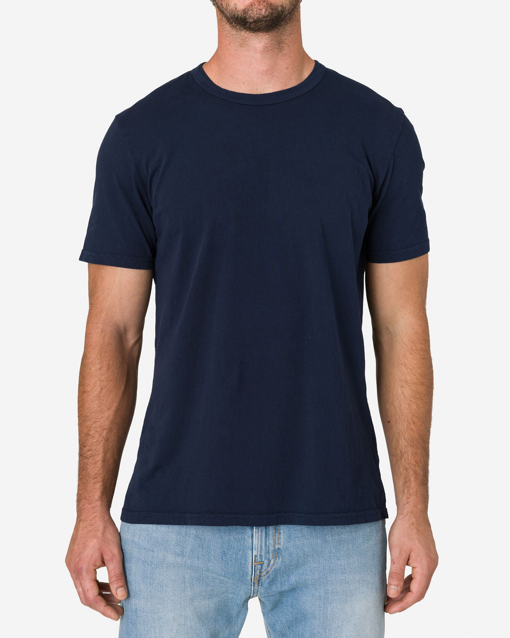 Man wearing an Ace Rivington Super Soft Supima Cotton Tee in navy blue color paired with light blue jeans focuses on the upper body. The T-shirt has a simple, classic design with short sleeves and a crew neckline showcasing its fit and style.