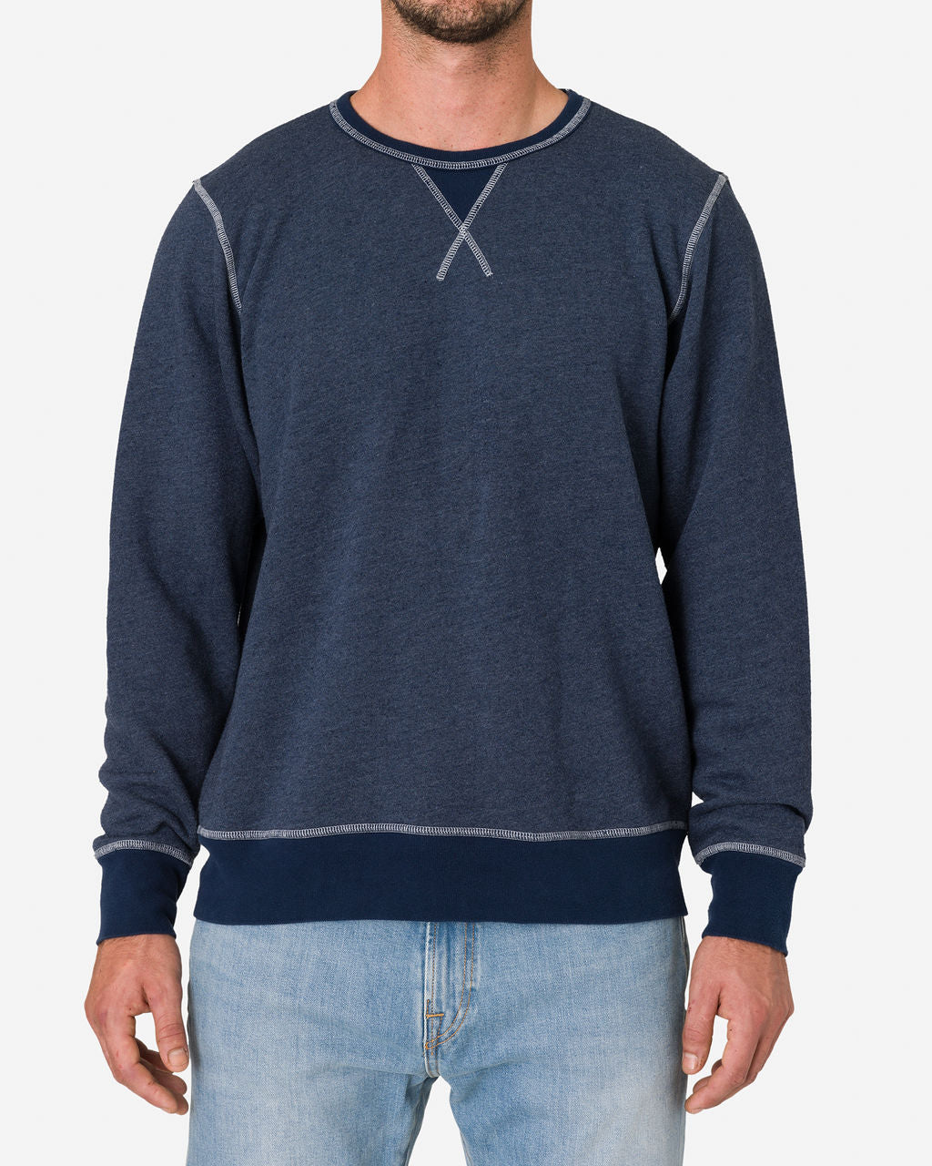 Man wearing a French Terry Vintage Soft Crewneck Sweatshirt in Navy Heather by Ace Rivington paired with light blue jeans. The sweatshirt features a classic crewneck design with visible stitching details, including an 'X' stitch at the neckline and contrasting seams on the shoulders and cuffs. The overall look is casual and comfortable.