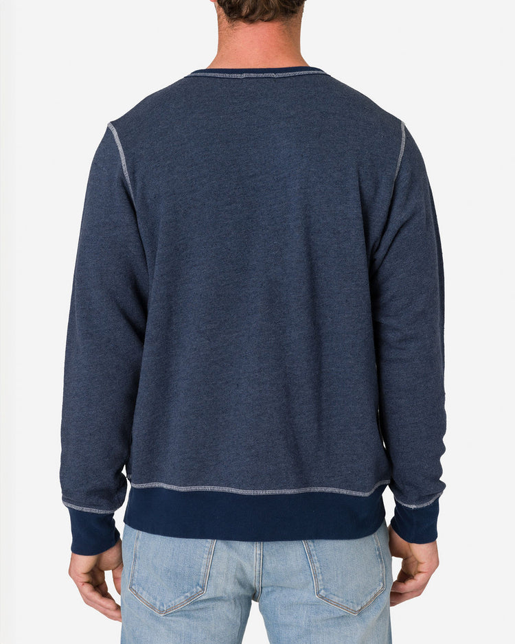 Man wearing a French Terry Vintage Soft Crewneck Sweatshirt in Navy Heather color and light blue jeans by Ace Rivington shown from the back. The sweatshirt has visible stitching along the seams and cuffs.