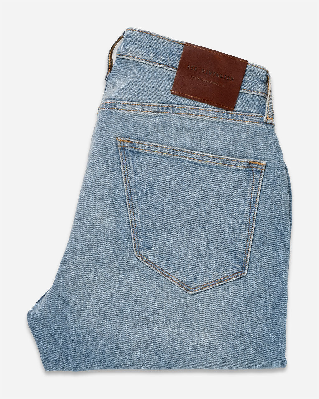 Folded pair of Athletic Taper Denim Jeans - Light Vintage with a visible back pocket and a brown leather patch on the waistband.