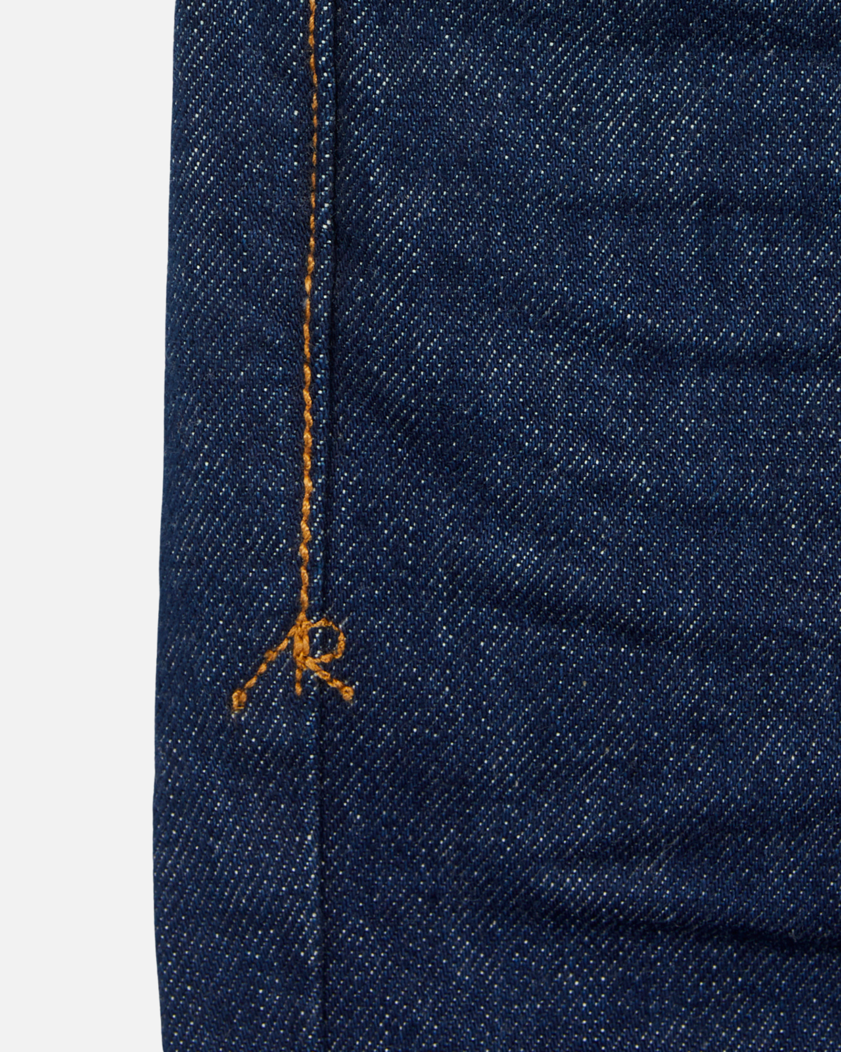 close up of stitching on pair of dark blue athletic taper jeans with no wear