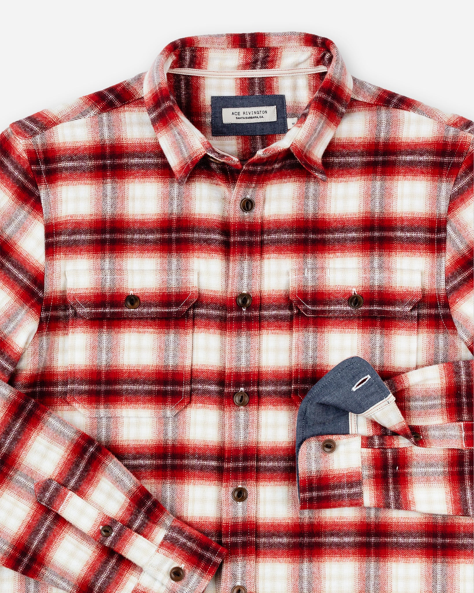 Flannel Utility Shirt - Brick Window by Ace Rivington features a button-up front and two chest patch flap pockets. Made from a heavy brushed flannel fabric, this shirt offers a super soft hand feel. It has a classic collar, Corozo cat-eye buttons, and folded cuffs that reveal a contrasting blue inner lining. Made from 100% cotton and heavily pre-washed to minimize shrinkage, this shirt provides a true-to-size overshirt fit.