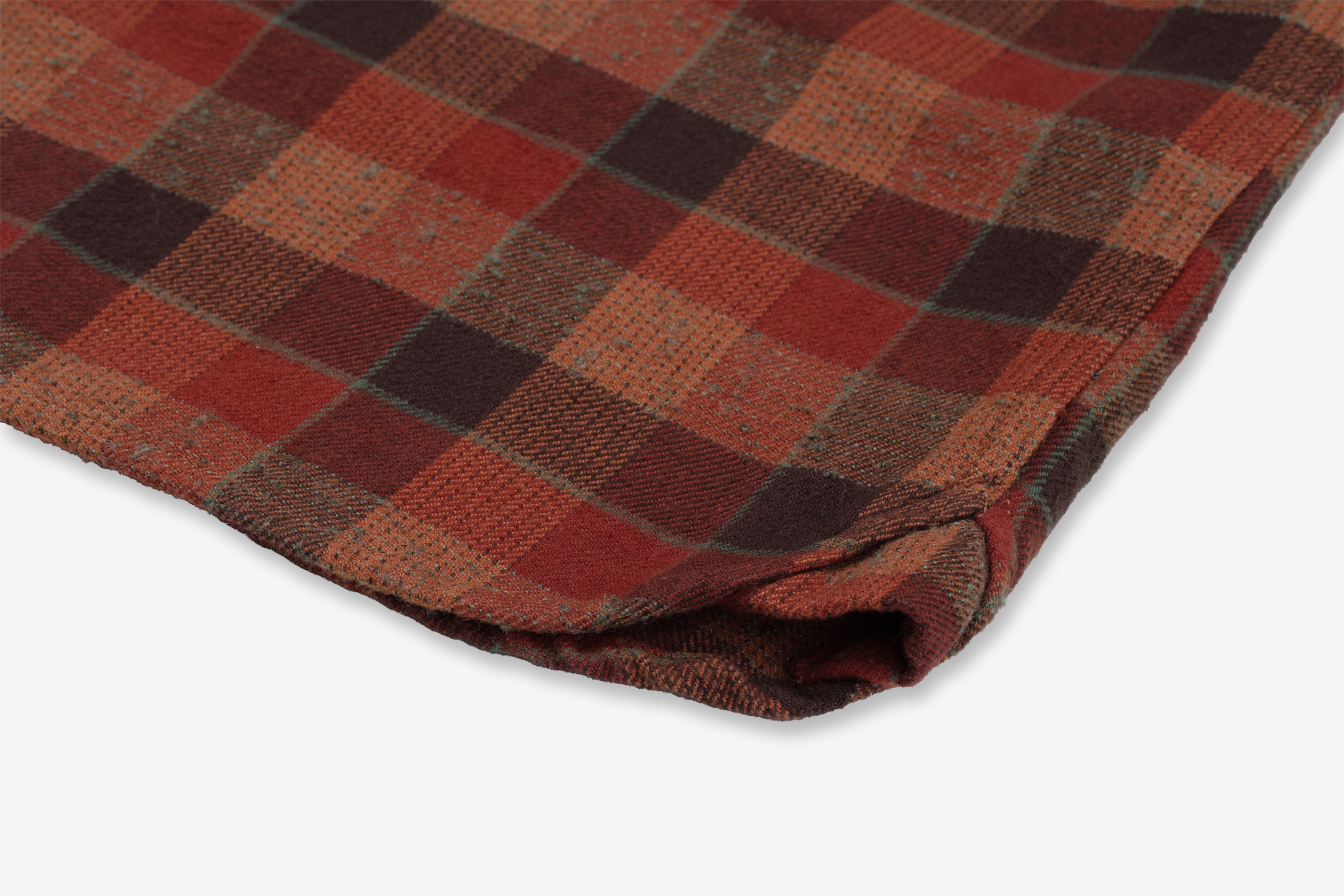 A close-up view of a folded clay tile Flannel Utility Shirt by Ace Rivington showcases a plaid pattern in shades of red, brown, orange, and yellow. The texture of the heavy brushed flannel fabric is visible, highlighting its soft, woven material, which creates an exceptionally soft hand feel.