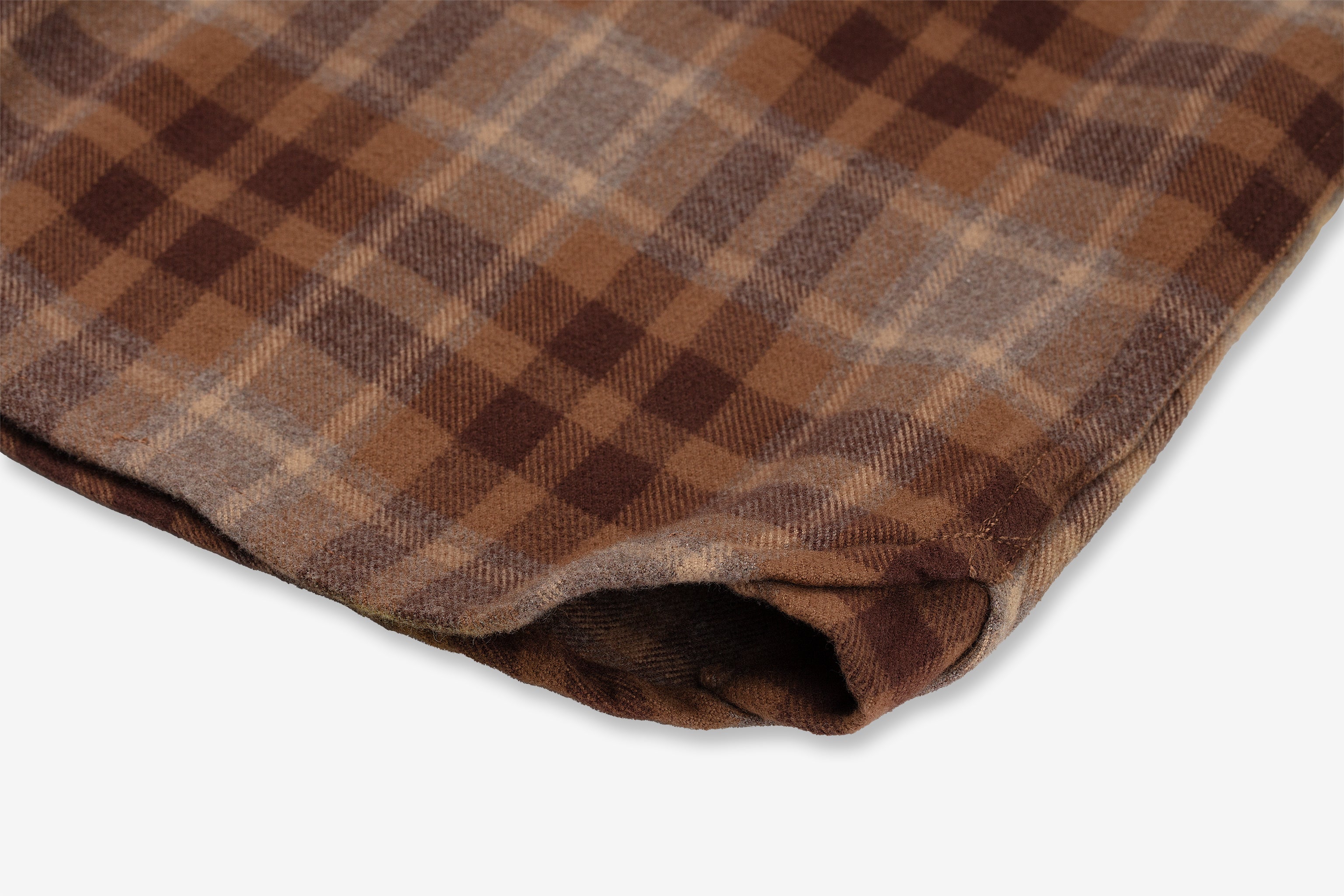 A close-up view of a folded, desert bark-colored flannel utility shirt by Ace Rivington. The fabric looks soft and warm, likely made of heavy brushed flannel, making it ideal for cozy clothing or home decor. It is made from 100% cotton and has been heavily pre-washed to minimize shrinkage.