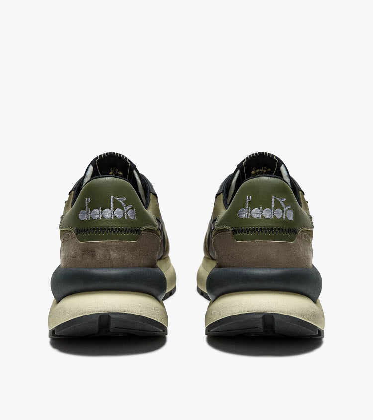 Rear view of the Ace Rivington Diadora - Mercury Elite - Beech Green, highlighting the retro-inspired design with embroidered Diadora branding, a mix of suede and leather materials, and the oversized stabilizer. The olive green and brown tones emphasize its 1970s track shoe aesthetic.