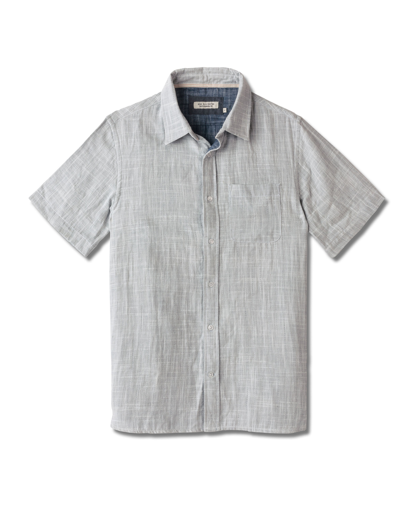 Front of full-view flat lay of Ace Rivington collared grey short-sleeved double gauze soft-textured cotton shirt with indigo blue interior, pearl buttons, and left-breast pocket