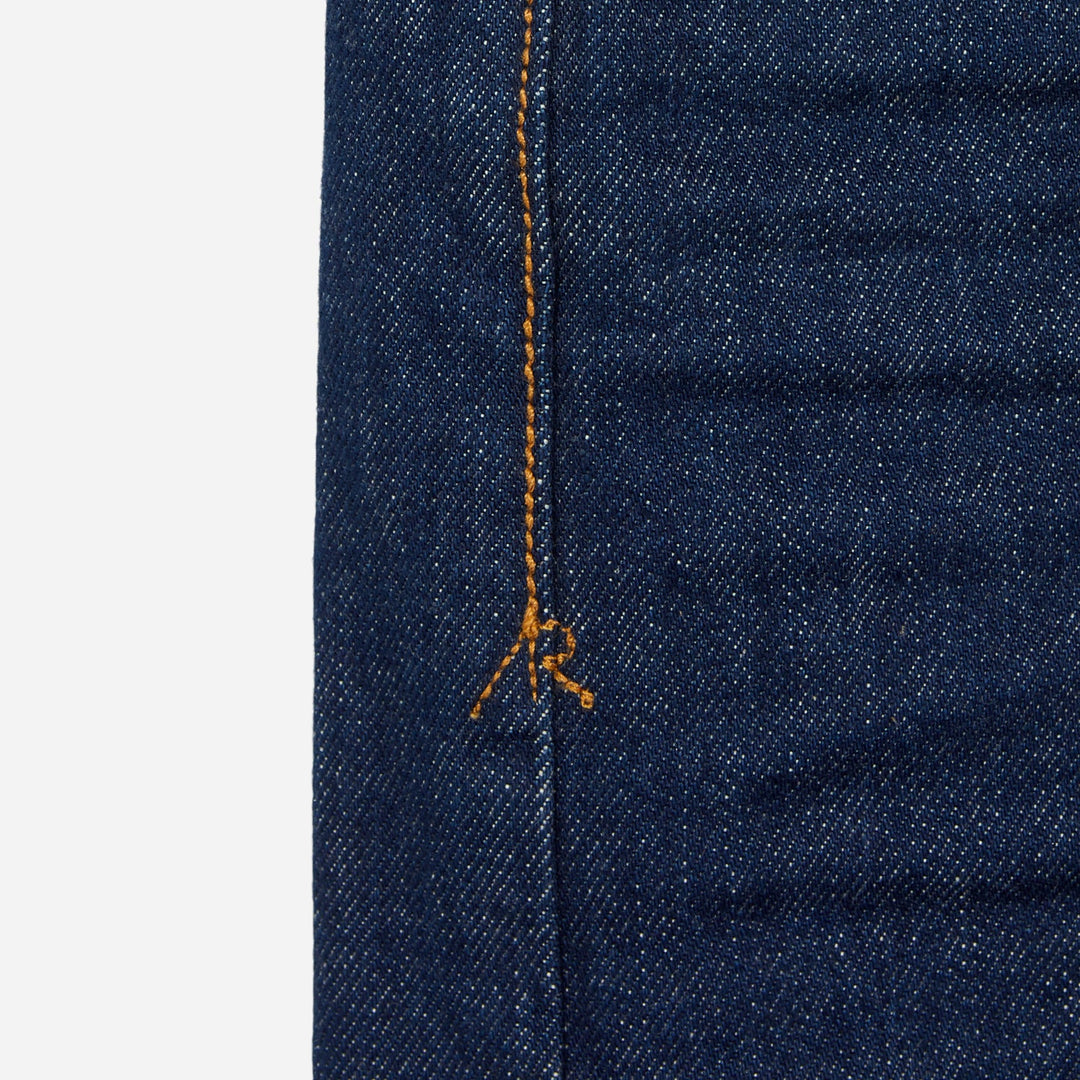 close up of stitching of pair of high quality slim cut men's dark blue jeans with no wear