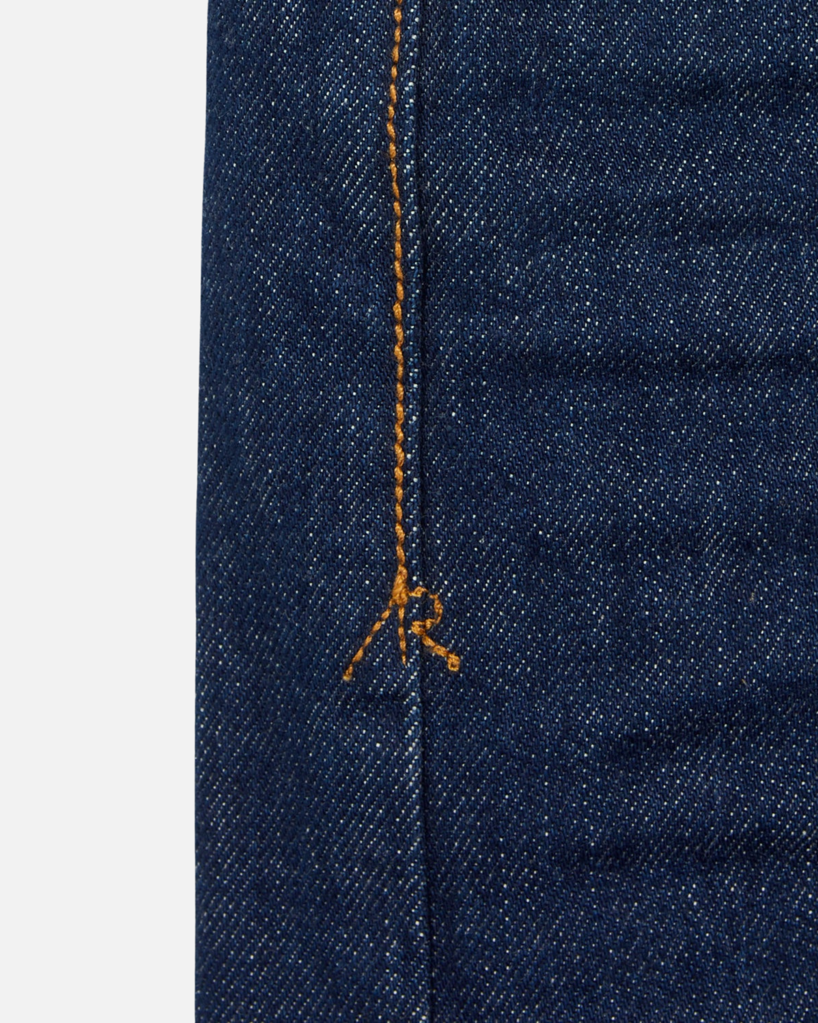 close up of stitching of pair of high quality slim cut men's dark blue jeans with no wear