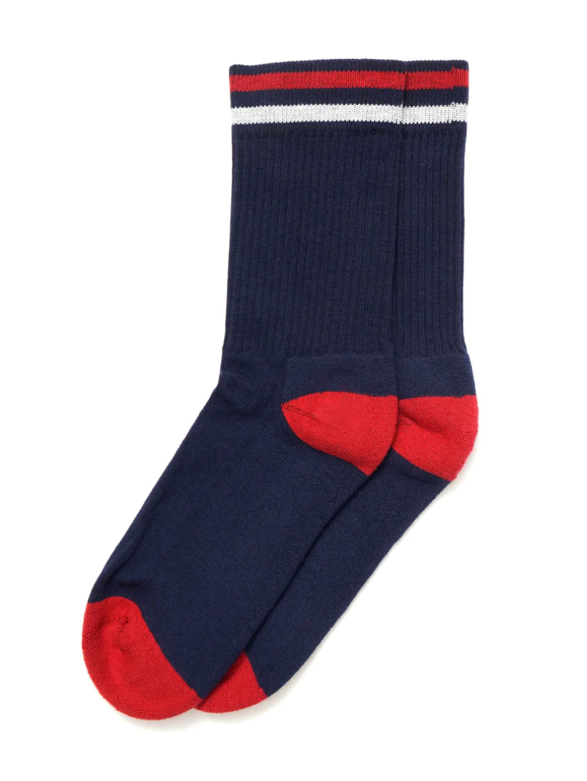 A pair of navy blue Ace Rivington American Trench Kennedy Socks features red accents on the toes and heels, along with a ribbed texture. The top of the socks displays a red, white, and blue striped pattern.