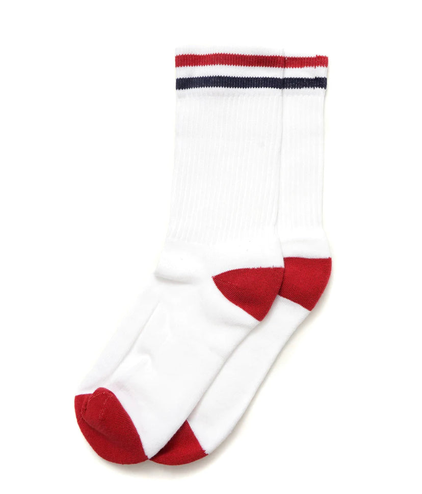 A pair of white Ace Rivington American Trench Kennedy Socks features red accents on the toes and heels, along with a ribbed texture. The top of the socks displays a red and blue striped pattern.